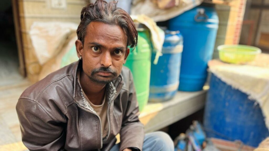 Ramesh sits outside his flat in Delhi.